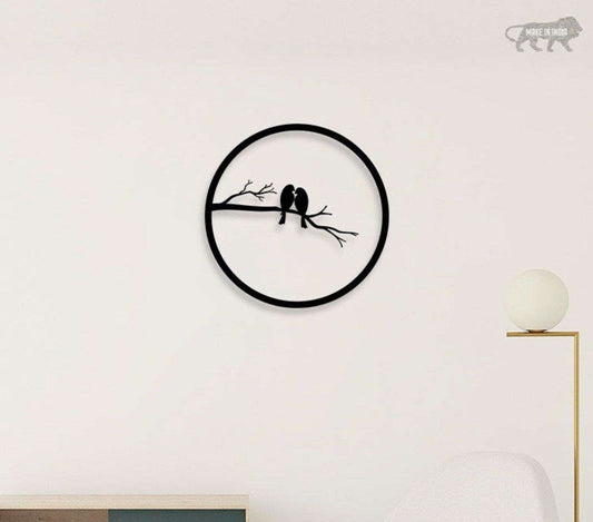 Decorative wall clock with birds design on a white wall.