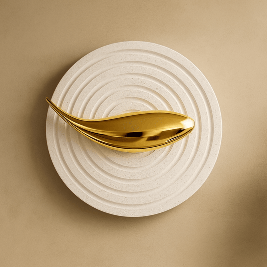 Gold decorative object on a textured beige surface