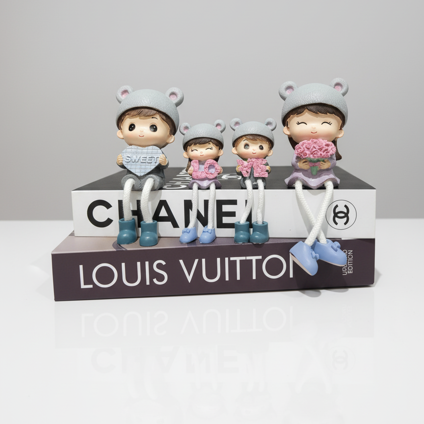 Four small figurines on a Chanel and Louis Vuitton box