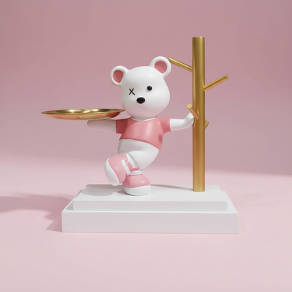 White bear figurine with pink shirt and shoes holding a gold tray on a pink background