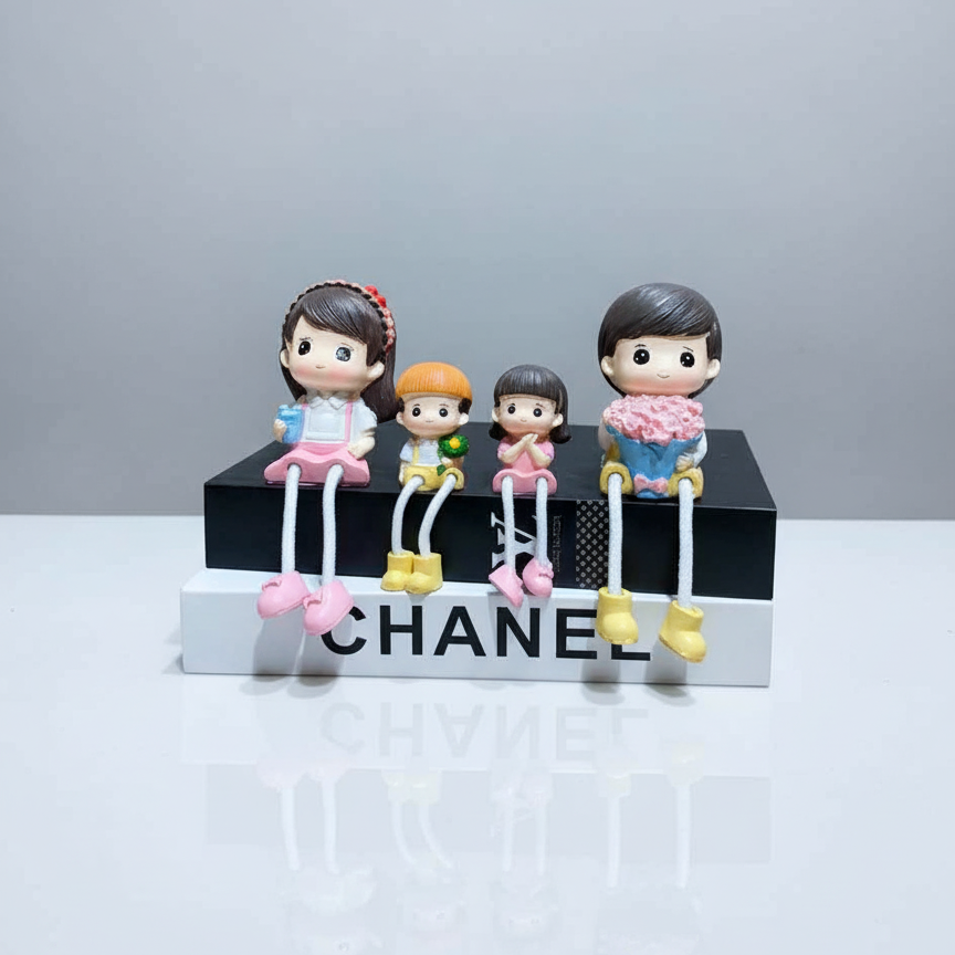 Four small figurines on a Chanel box with a gray background