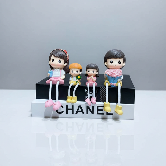 Four small figurines on a Chanel box with a gray background
