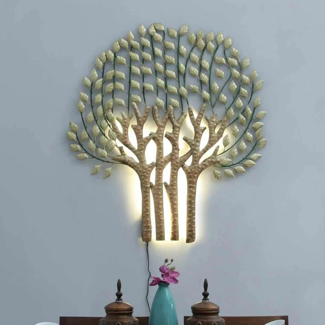 Decorative wall light shaped like a tree with leaves on a gray wall above a dining table.