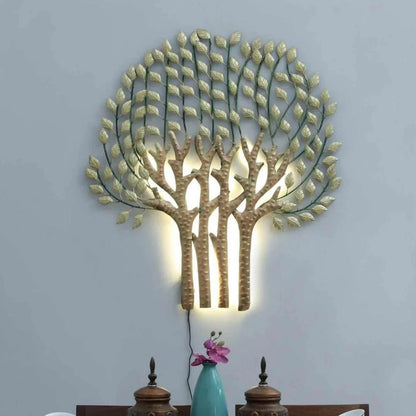 Decorative wall light shaped like a tree with leaves on a gray wall above a dining table.