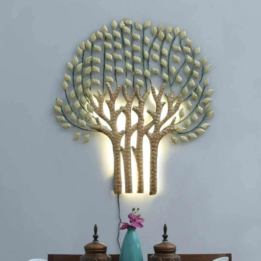 Decorative wall light shaped like a tree with leaves on a gray wall above a dining table.